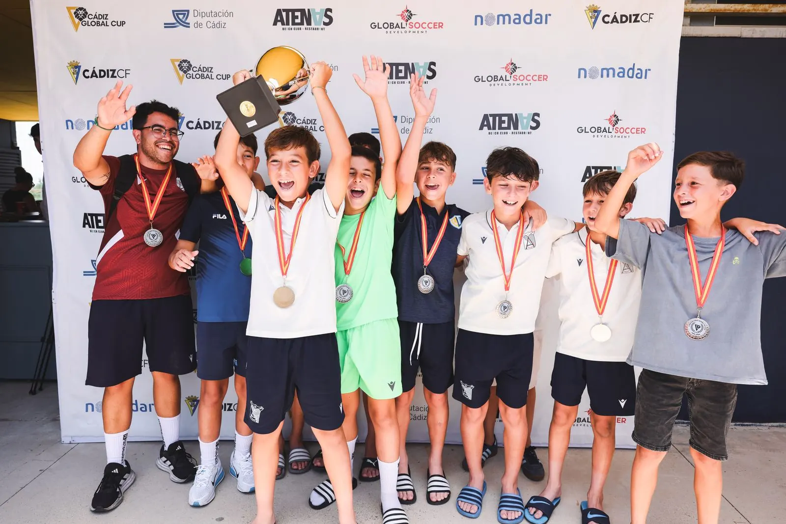Equipo celebrando en el podio con sus medallas