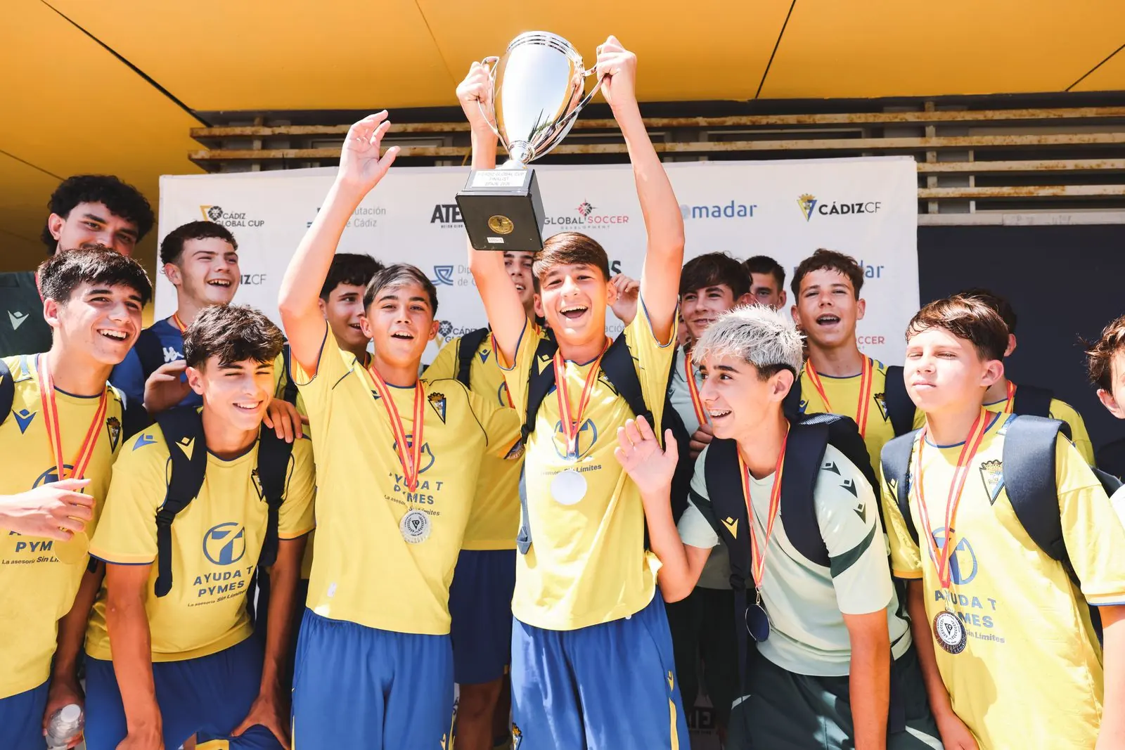 Jugadores levantando el trofeo de campeones con sus medallas